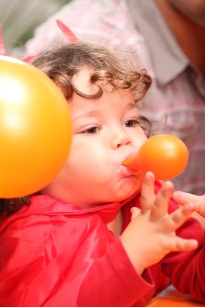 Ребёнок надувает воздушный шар — стоковое фото