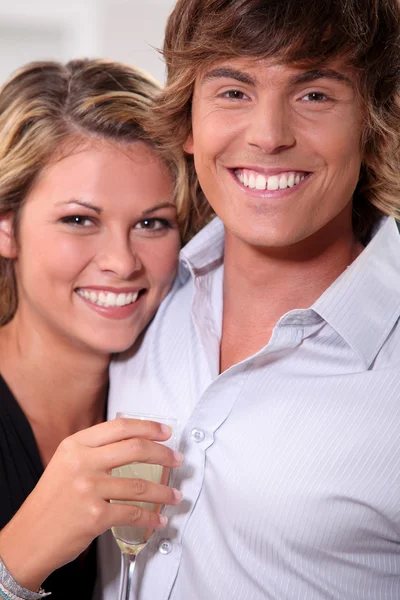 Νεαρό ζευγάρι με toothy χαμόγελο και φλάουτο κρασί — Φωτογραφία Αρχείου