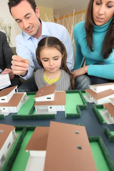 Jonge gezin kijken naar model huisvesting — Stockfoto