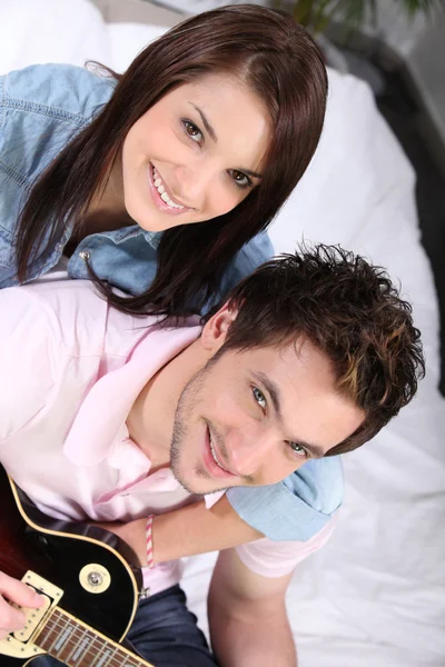 Lachende vrouw en man met gitaar — Stockfoto