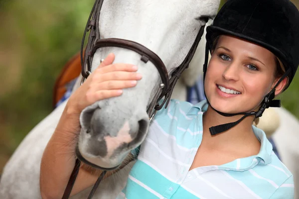 Jonge vrouw strelen haar paard — Stockfoto