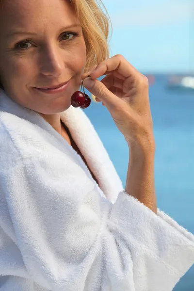 50 anos de idade mulher loira vestida de roupão de banho na frente do mar tomando ch — Fotografia de Stock