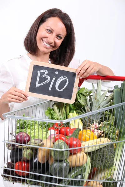 Femme avec un chariot de légumes biologiques — Photo