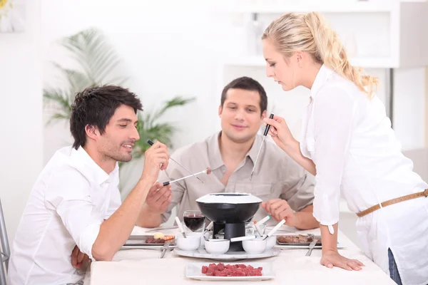 Drie genieten van fondue — Stockfoto