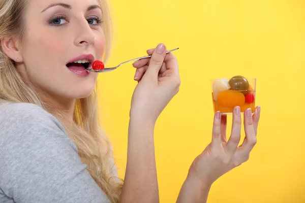 Женщина ест фруктовый коктейль — стоковое фото