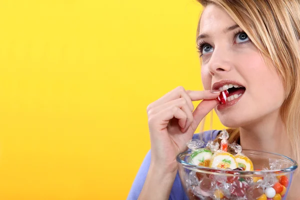 Een vrouw genieten van snoepjes. — Stockfoto