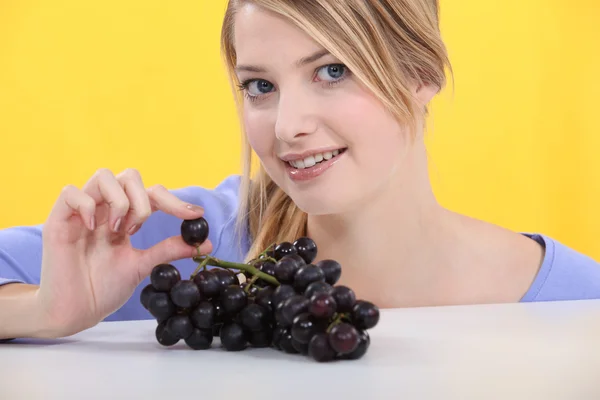 Mulher com um monte de uvas pretas — Fotografia de Stock