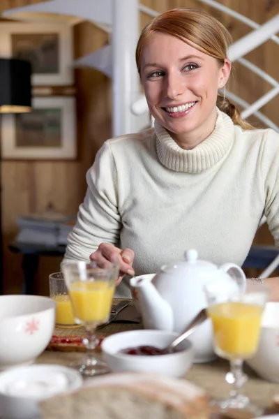 महिला टेबलावर नाश्ता खाते — स्टॉक फोटो, इमेज