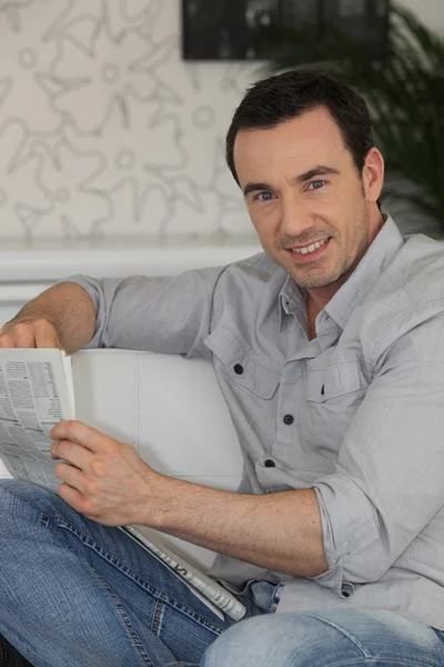 Uomo che legge il giornale a casa — Foto Stock