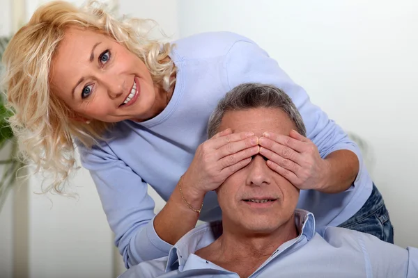 Wife covering the eyes of her husband — Stock Photo, Image
