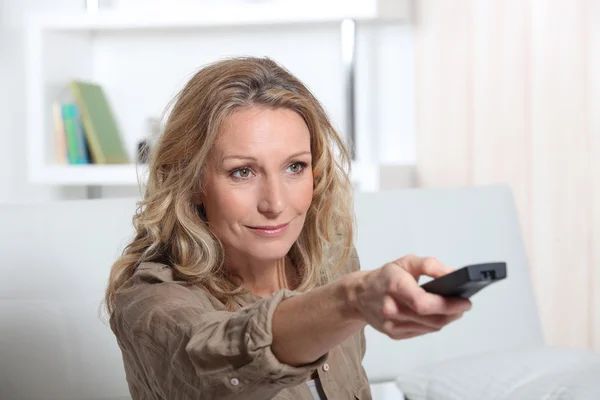 Portrait of a woman with remote control — Stock Photo, Image