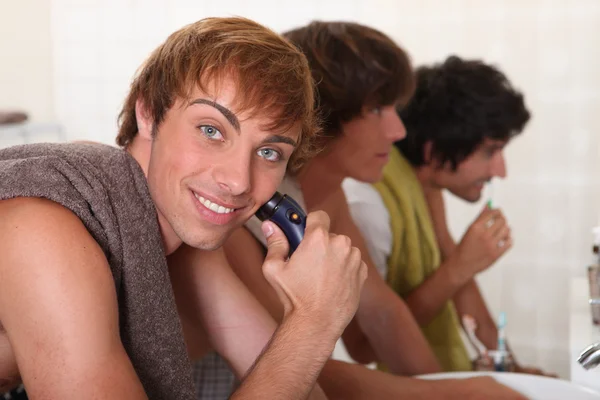 Jonge mannen scheren en tanden poetsen — Stockfoto