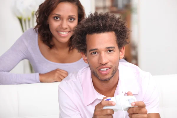 Жінка дивиться на свого хлопця, граючи у відеоігри — стокове фото
