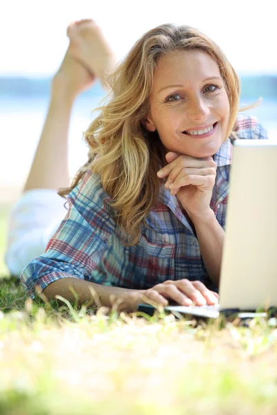 Kobieta korzysta z laptopa na zewnątrz w słoneczny dzień — Zdjęcie stockowe