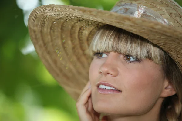 Woman outdoors wearing straw hat — Stock Photo, Image