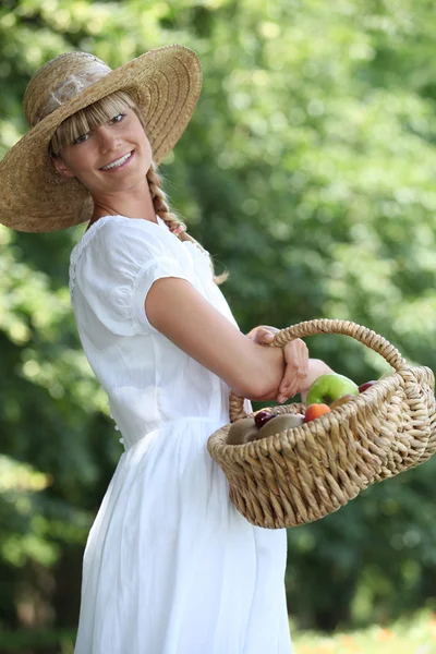 Молодая женщина с корзиной свежих фруктов — стоковое фото