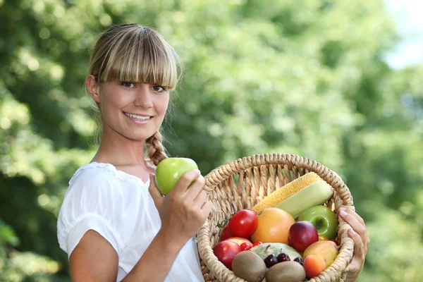 Vrouw met een mand fruit — Stockfoto