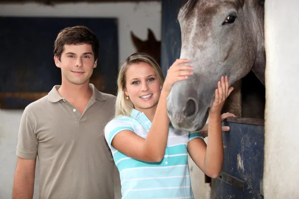 Молодая пара стояла на лошади — стоковое фото