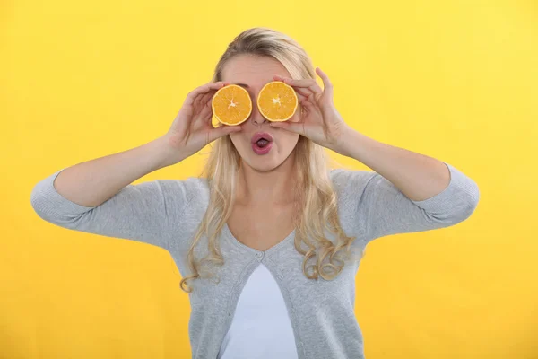 Женщина с апельсинами для глаз — стоковое фото