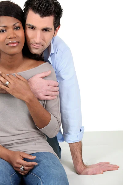 Um casal interracial abraçando — Fotografia de Stock