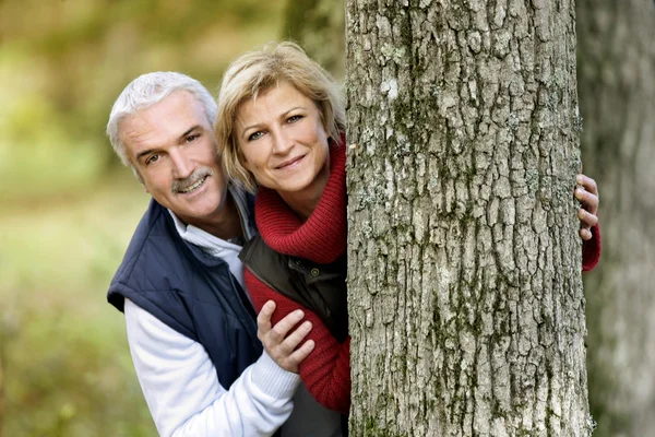 Paar versteckt sich hinter Baum — Stockfoto