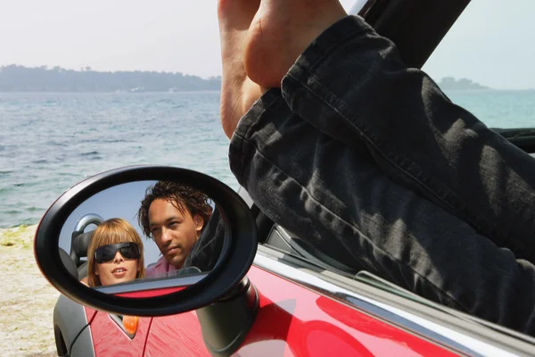 Couple sat in car at the beach — Stock Photo, Image
