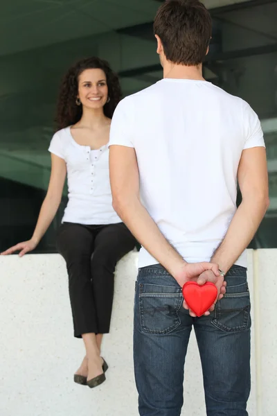 Mann überrascht Frau mit herzförmigem Geschenk — Stockfoto
