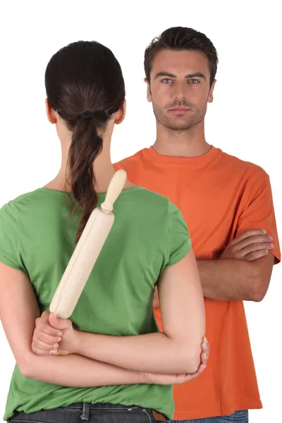 Woman hiding a rolling pin behind her back — Stock Photo, Image