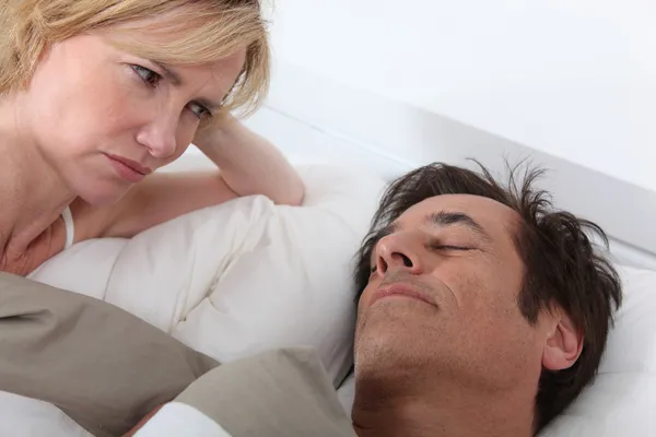 Frau beobachtet schlafenden Ehemann — Stockfoto