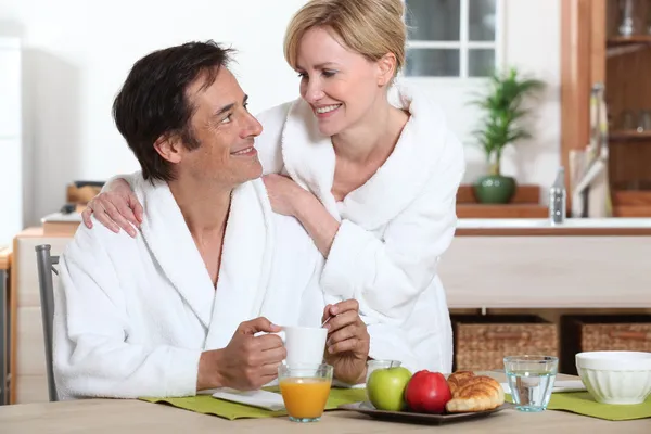 Paar in badjassen eten ontbijt — Stockfoto