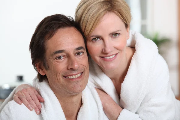 Sorrindo casal maduro em roupões de banho — Fotografia de Stock