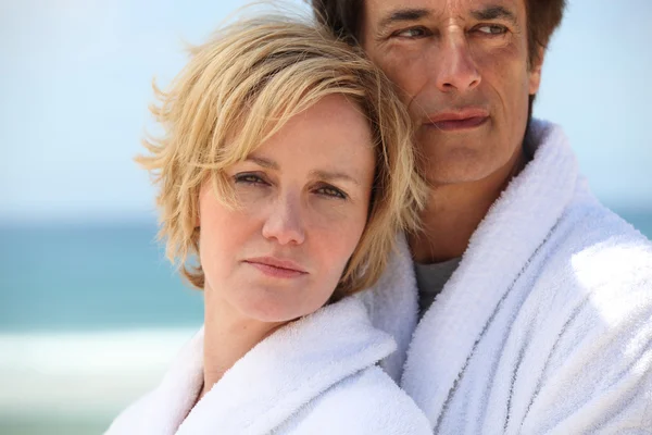 Paar op het strand dragen kamerjassen — Stockfoto