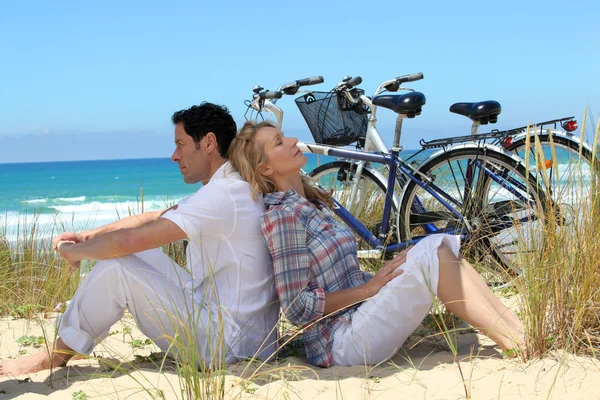 Пара на пляже с велосипедами — стоковое фото