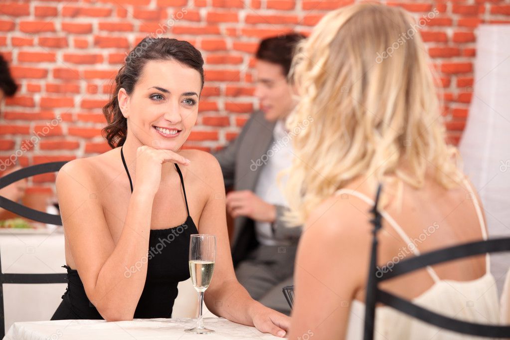 Garçonete bonita servindo grupo de amigas com comida no restaurante