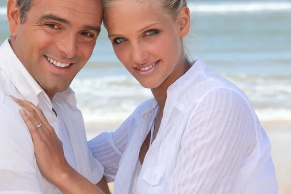 Casal vestindo roupas brancas ficou em uma praia — Fotografia de Stock
