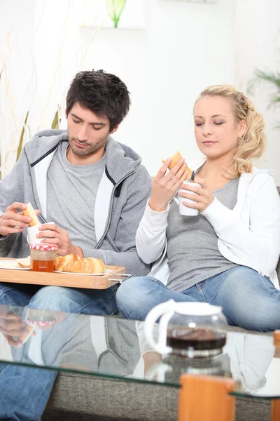 Par med frukost i soffan — Stockfoto