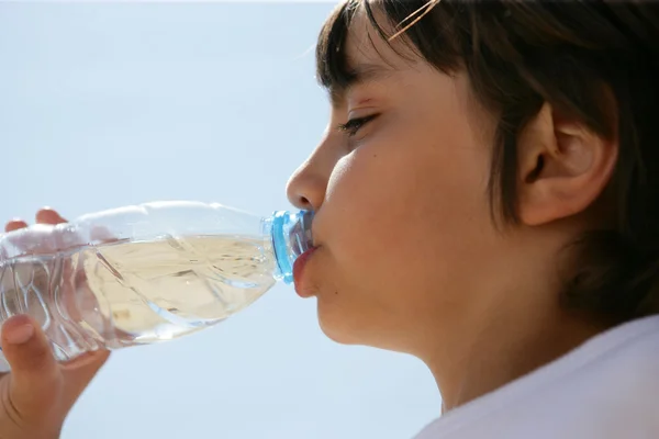 Chlapec pitnou vodu v lahvi — Stock fotografie
