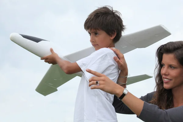 Madre e figlio giocare con un grande modello di aeroplano giocattolo — Foto Stock