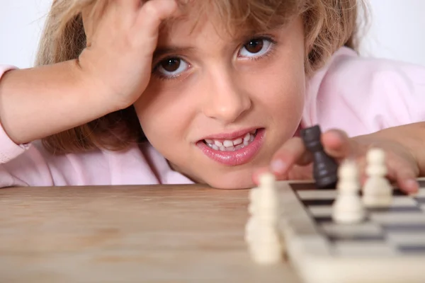 Little girl playing chess alone — Stock Photo, Image