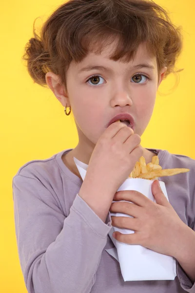 Young girl eating fries — Stock Photo, Image