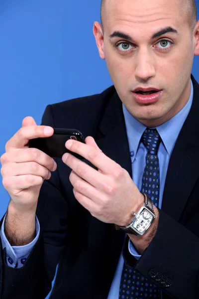 Empresario jugando con su celular — Foto de Stock