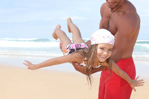 Man zijn dochter rond een beach vliegen — Stockfoto