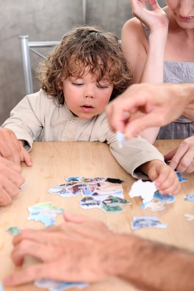 Little boy playing with pictures at a table — Stock Photo, Image