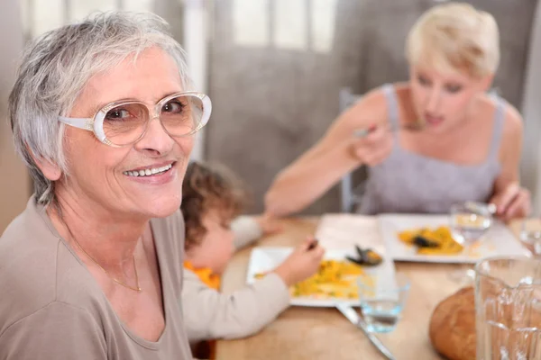 Babička se připojí k neformální rodinné večeři — Stock fotografie