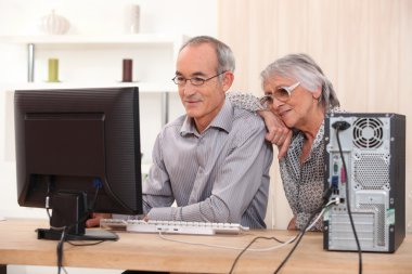 Elderly couple learning computer skills clipart