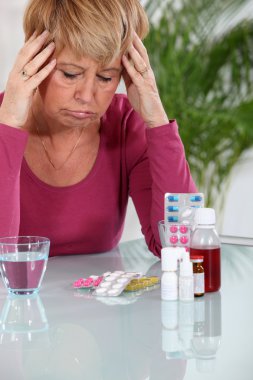 Senior woman taking pills clipart