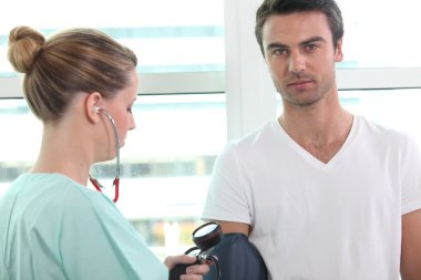 Nurse taking blood pressure clipart