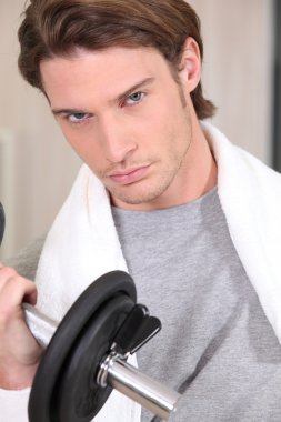 Portrait of a determined man lifting a dumbbell clipart