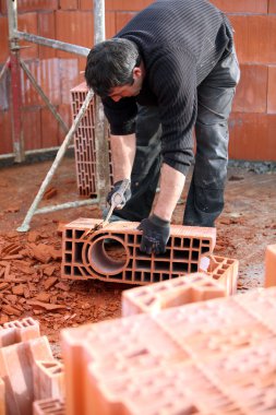 Workman sculpting a brick clipart