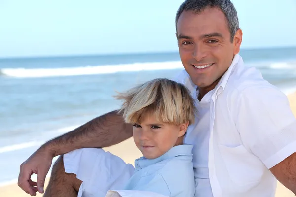 Far med sin son på stranden — Stockfoto